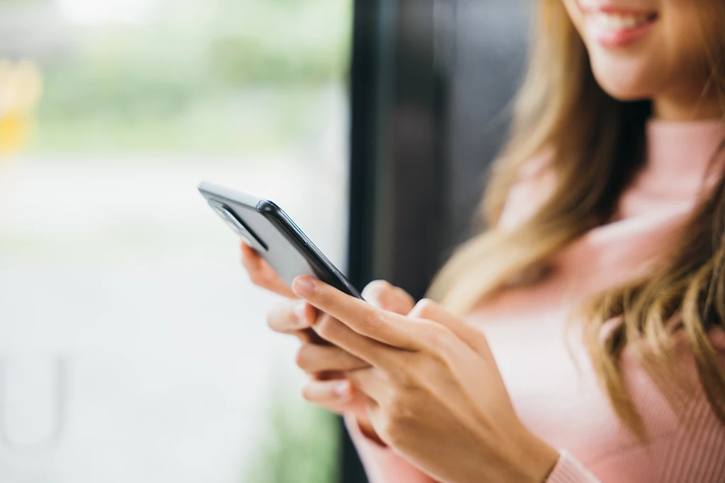 Jeune femme écrivant un message sur son smartphone
